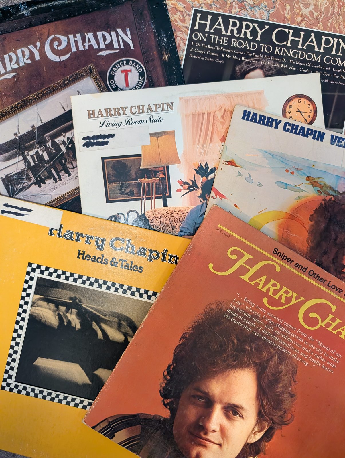 A group of Harry Chapin LPs on a dark surface