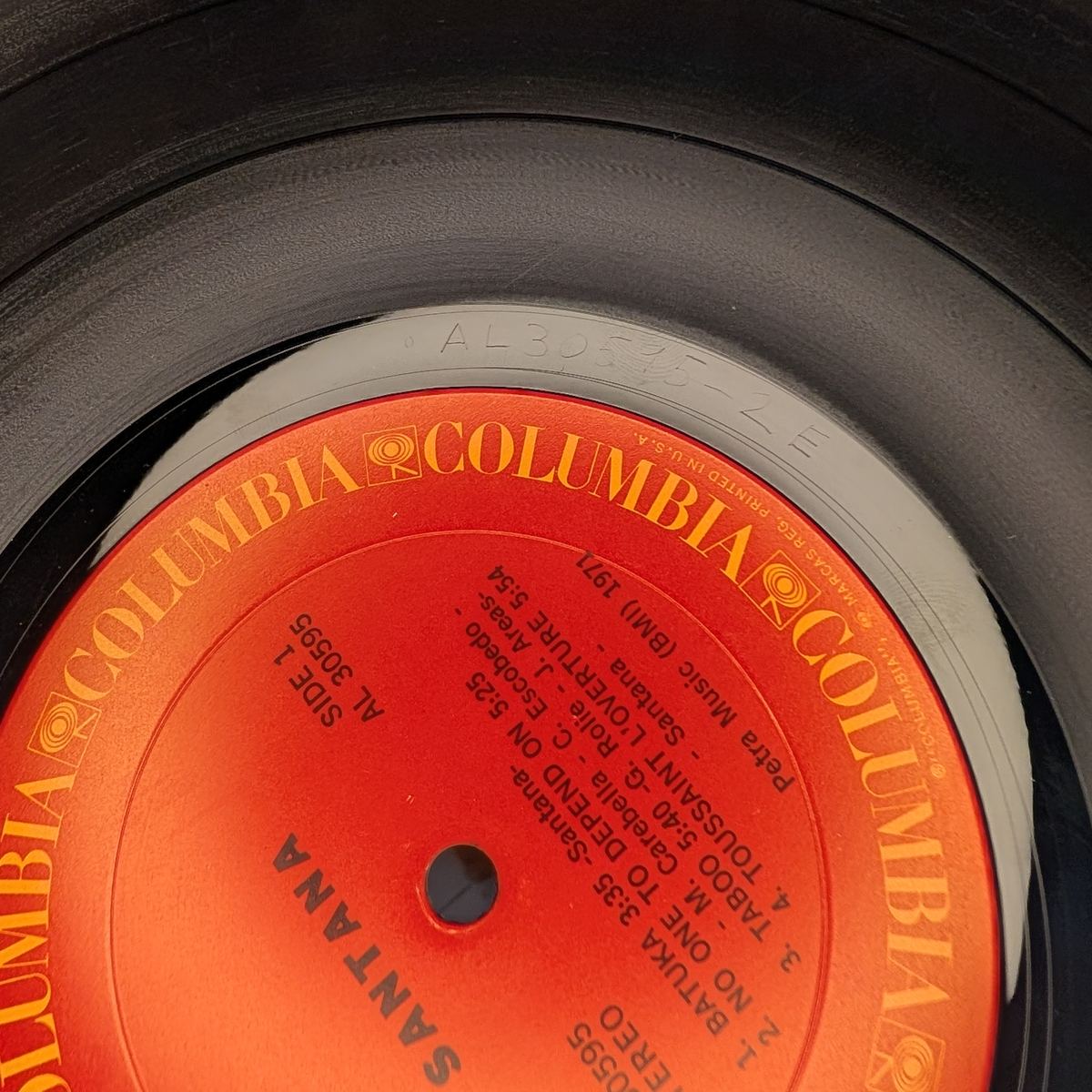 Close-up of a Santana LP on a red Columbia label, with AL 30595 in the dead wax above the label